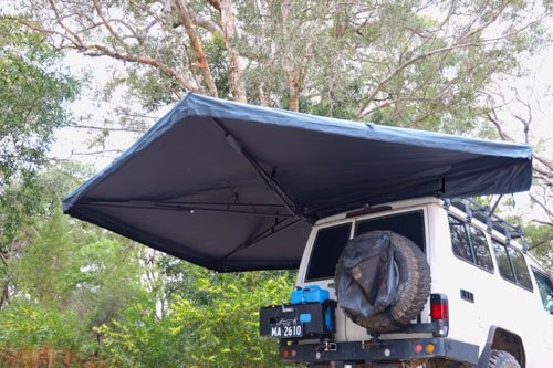 Shelta 270 awning open over the back of a 4WD at a bush campsite