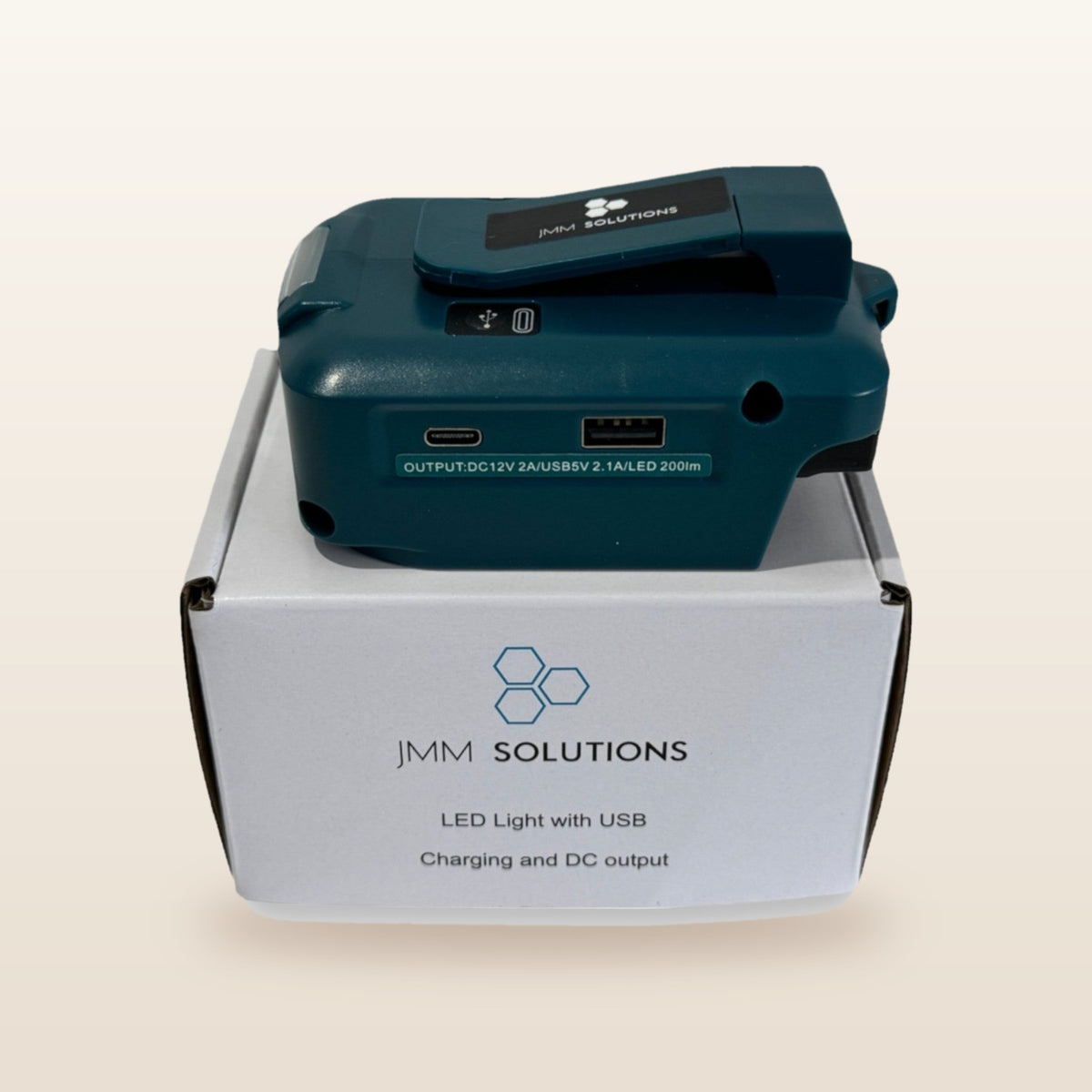 Makita-compatible USB & 12V Charger with LED Light: standing on its box
