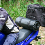Rolled Biker Swag strapped to the back seat of a motorbike