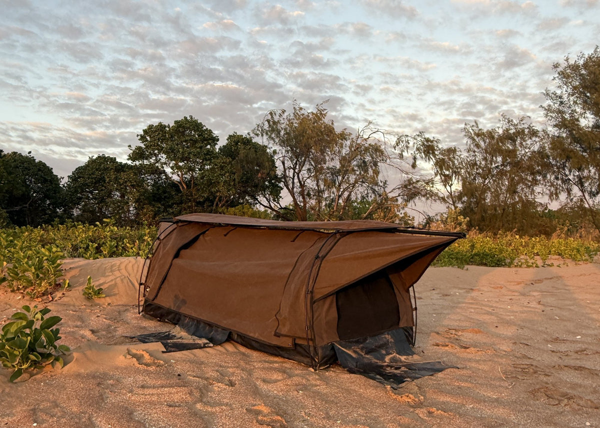 Mr Swagman dome swag pitched on the sand behind a beach at sunrise