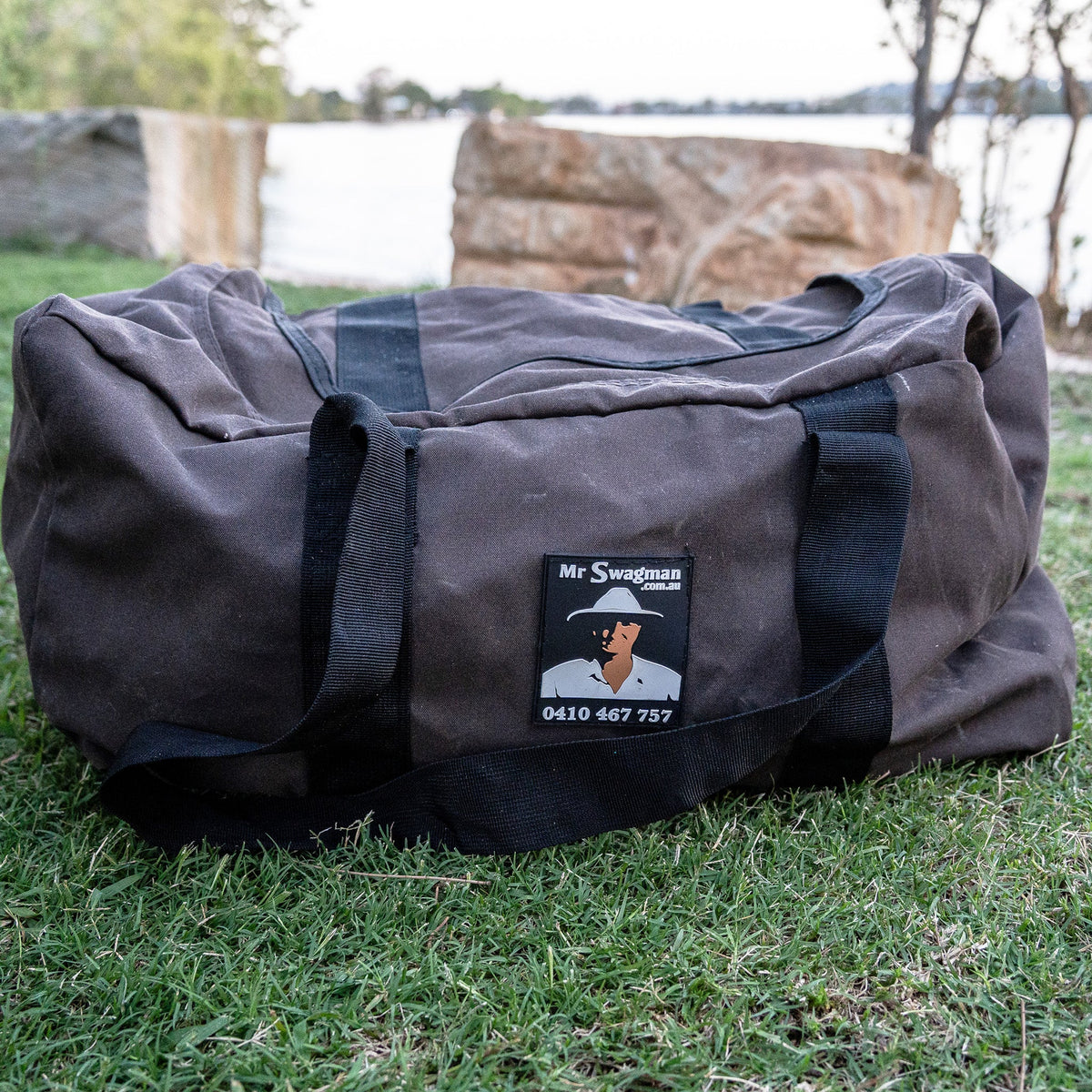 Mr Swagman Premium Canvas Gear Bag 96L on grass by a river