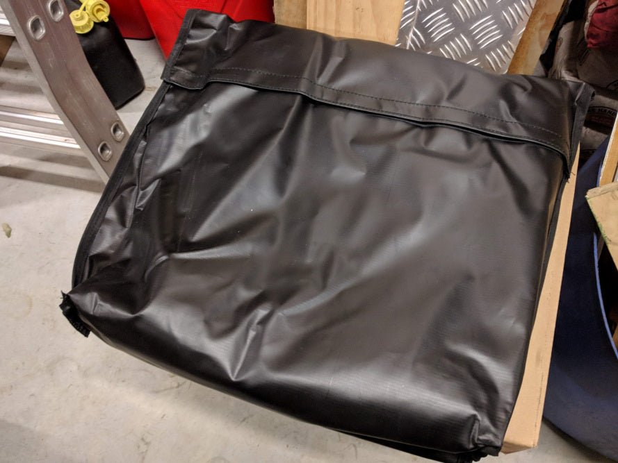 Premium Canvas Tarp folded into its black PVC storage bag