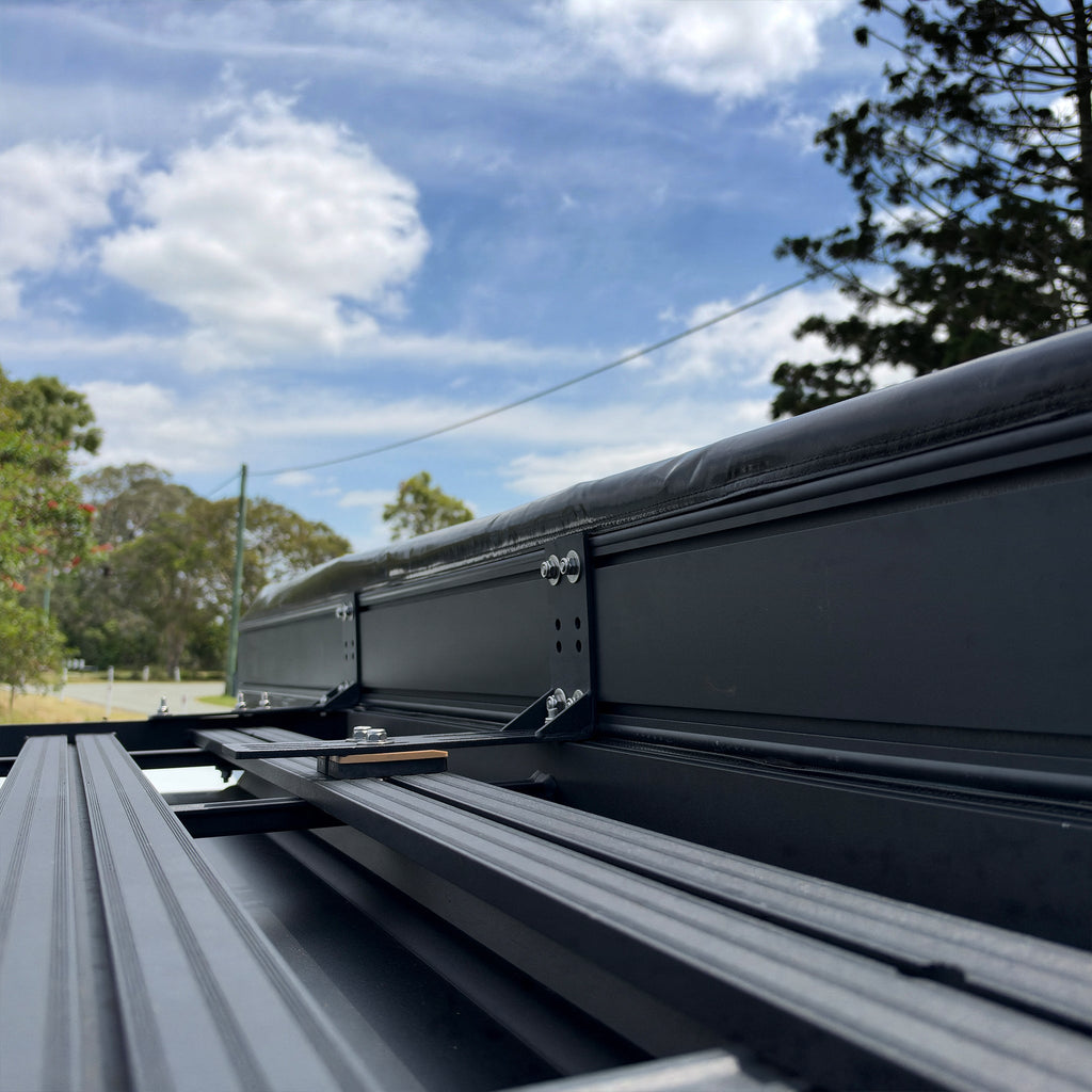 Shelta 270 awning case mounted on a flat roof rack with L-brackets