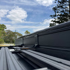 Shelta 270 awning case mounted on a flat roof rack with L-brackets