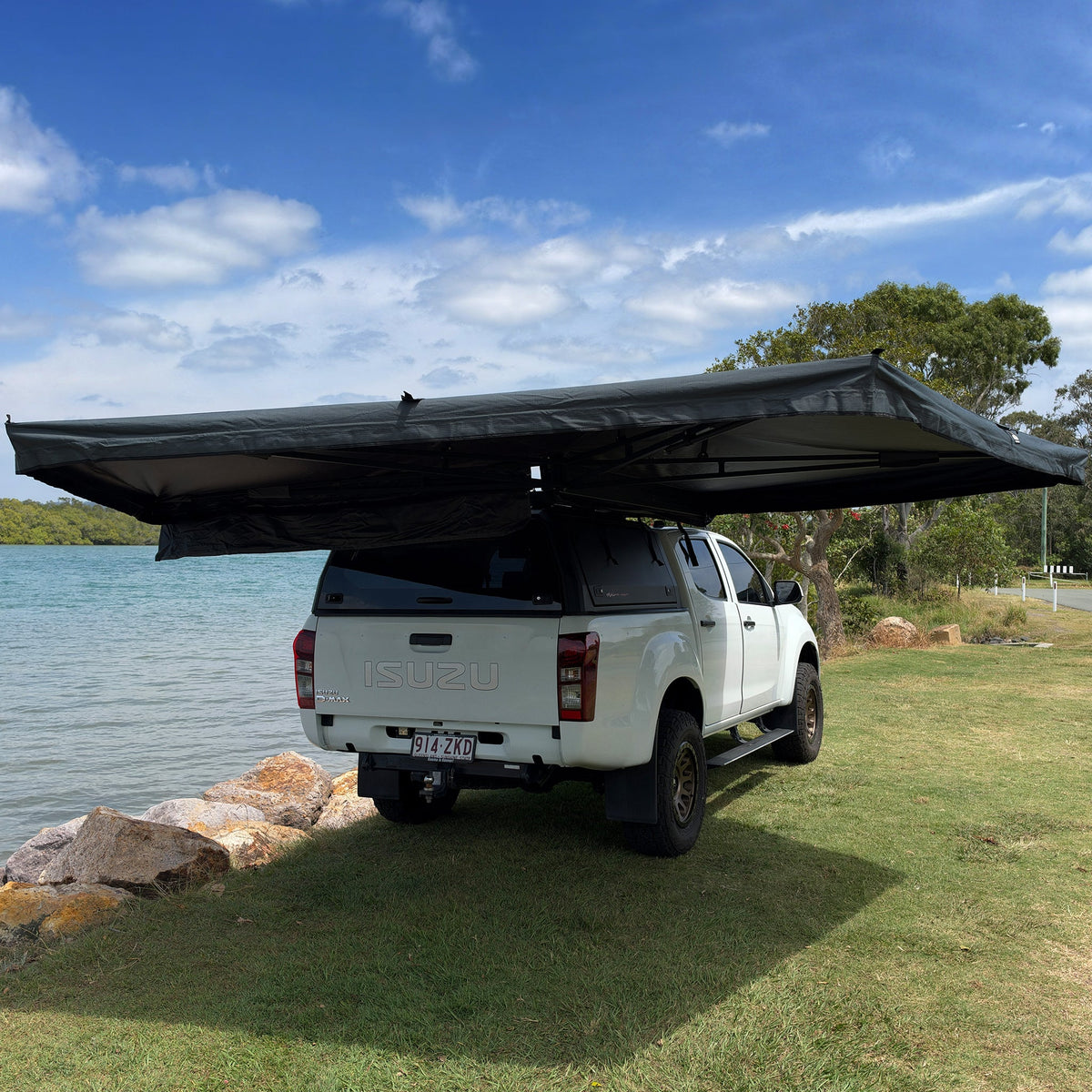 Mr Swagman Shelta 270 awning open around the side and rear of a white ute beside the water
