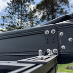 Close-up of a Shelta 270 L-bracket bolted between the awning case and the roof rack