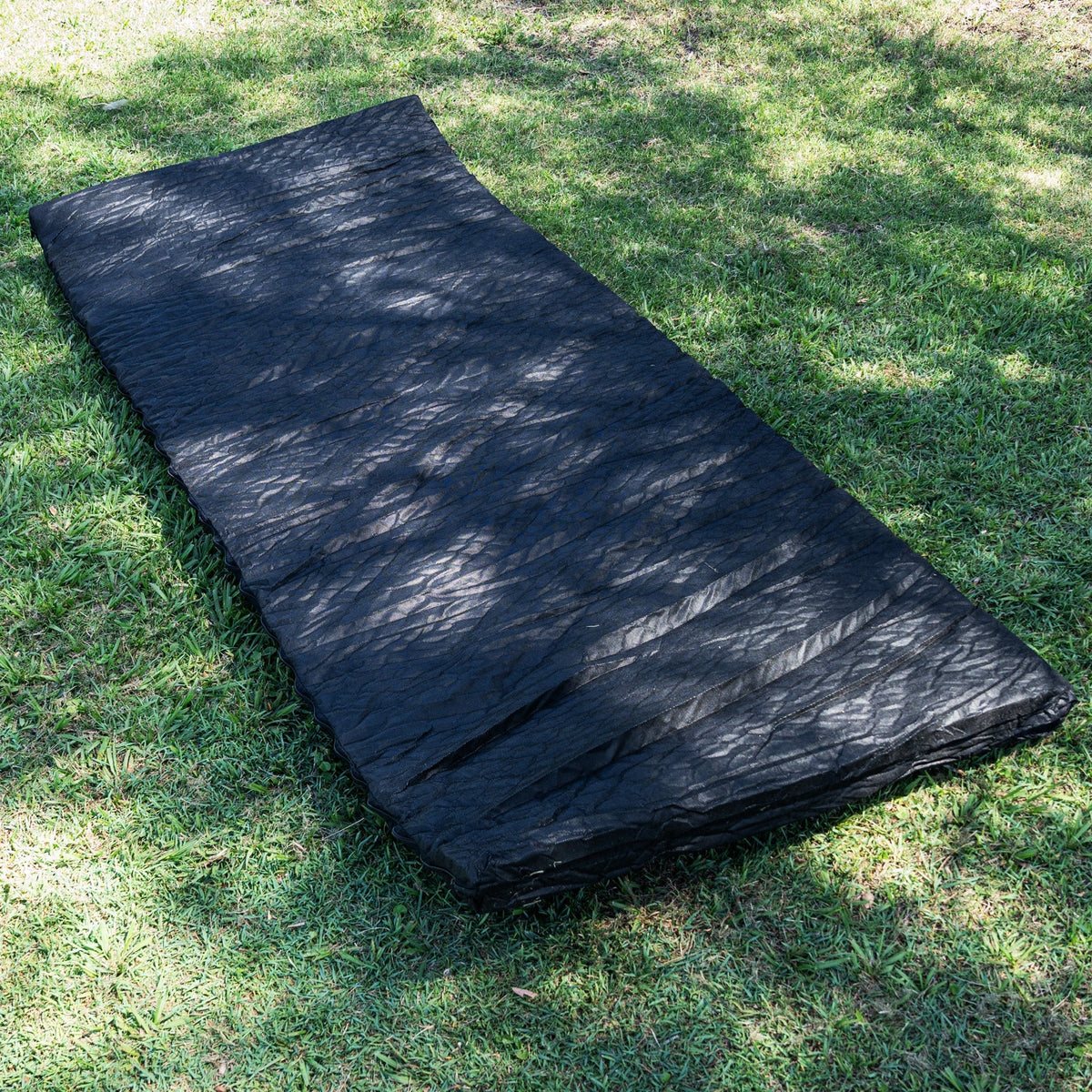 80mm foam mattress from the Ultimate King Single Swag laid on grass